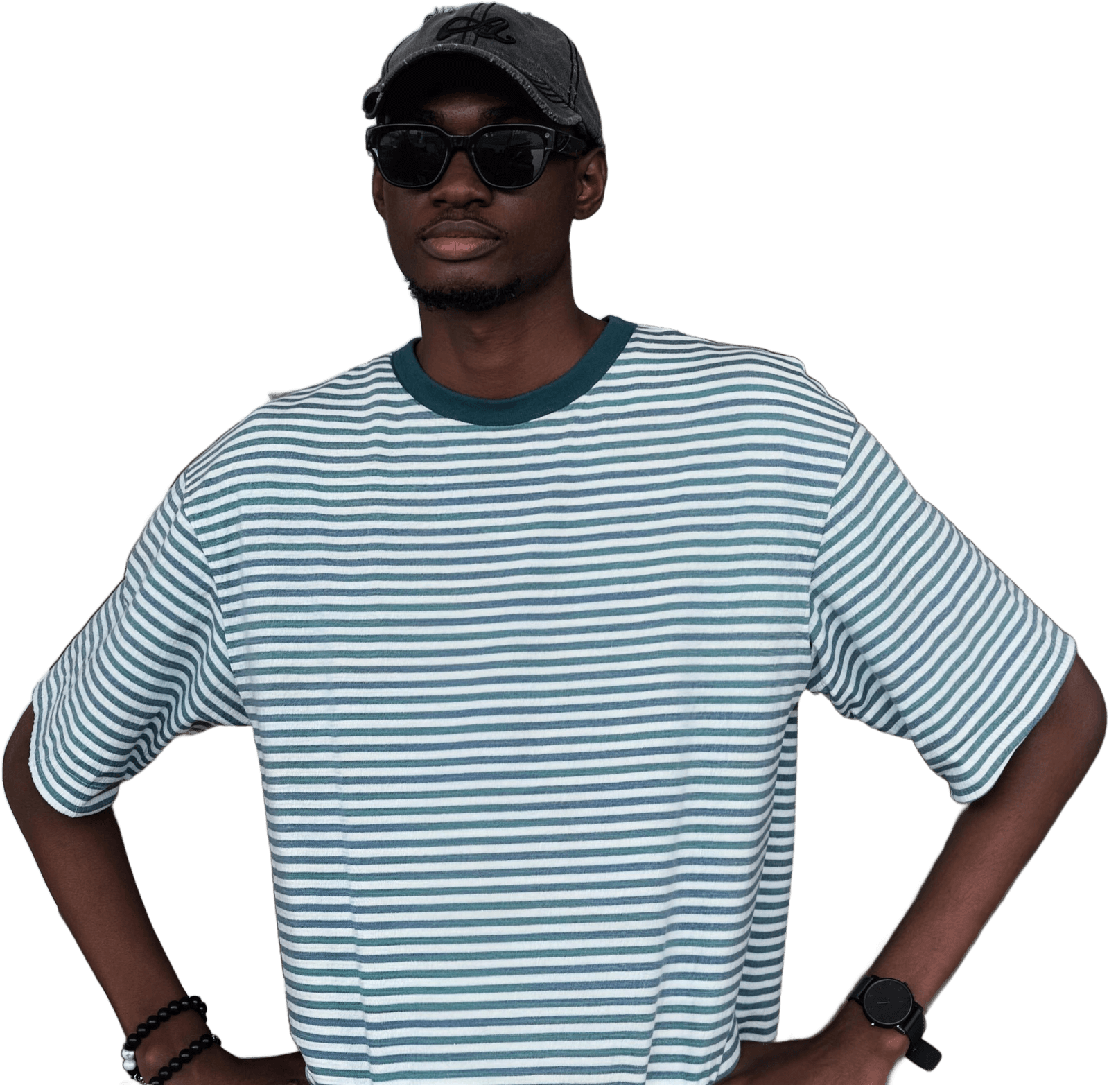 Toyan in a striped tee, cap and sunglasses, hands on his hips